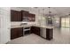 Modern kitchen featuring stainless steel appliances, granite countertops, and dark wood cabinetry at 22040 N 119Th Dr, Sun City, AZ 85373