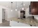 An island with granite countertops featuring stainless steel appliances and modern pendant lights at 22040 N 119Th Dr, Sun City, AZ 85373