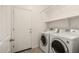 Laundry room featuring a side-by-side washer and dryer and storage shelves at 22040 N 119Th Dr, Sun City, AZ 85373