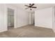 Neutral carpeted main bedroom with ceiling fan and access to an ensuite bathroom at 22040 N 119Th Dr, Sun City, AZ 85373