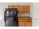 Kitchen with wood cabinets, black refrigerator, and neutral countertops at 2210 N 27Th Pl, Phoenix, AZ 85008