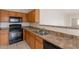 Kitchen featuring stainless steel sink, stove, microwave, neutral countertops, and wood cabinets at 2210 N 27Th Pl, Phoenix, AZ 85008