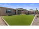 Backyard with lush artificial grass, a covered patio, gravel area, and a gazebo at 23097 E Camina Buena Vis, Queen Creek, AZ 85142