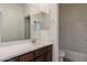 Bathroom with a white countertop vanity, dark wood cabinets, a large mirror, and a shower-tub combo at 23097 E Camina Buena Vis, Queen Creek, AZ 85142