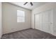 Bedroom featuring plush carpet, a double sliding-door closet, and a sunlit window at 23097 E Camina Buena Vis, Queen Creek, AZ 85142