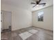 Bright bedroom featuring wood-look tile floors, neutral walls, ceiling fan, and a sunlit window at 23097 E Camina Buena Vis, Queen Creek, AZ 85142