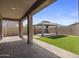 Spacious covered patio with brick pavers, pillars, and view of backyard gazebo at 23097 E Camina Buena Vis, Queen Creek, AZ 85142