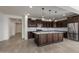 Spacious kitchen featuring dark wood cabinets, a large granite island, and stainless steel appliances at 23097 E Camina Buena Vis, Queen Creek, AZ 85142