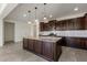 Kitchen featuring a large island with granite countertops, dark cabinetry, and stainless steel appliances at 23097 E Camina Buena Vis, Queen Creek, AZ 85142