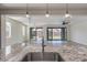 Open concept space with granite island, stainless faucet, and large sliding doors to the backyard at 23097 E Camina Buena Vis, Queen Creek, AZ 85142