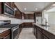 Well-appointed kitchen with stainless steel appliances, granite countertops, and dark wood cabinetry at 23097 E Camina Buena Vis, Queen Creek, AZ 85142