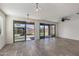 A bright living room with tile flooring, ceiling fan, and sliding doors to the outdoor patio and backyard at 23097 E Camina Buena Vis, Queen Creek, AZ 85142