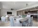 View of open-concept living and dining area with ample seating, modern lighting, and connection to the kitchen at 23097 E Camina Buena Vis, Queen Creek, AZ 85142