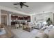 Open-concept living area showcases a bright, neutral color palette and blends seamlessly into the modern kitchen at 23097 E Camina Buena Vis, Queen Creek, AZ 85142