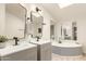 Bright bathroom showcases a dual sink vanity, soaking tub, modern fixtures and stylish mirrors at 231 N 88Th Way, Mesa, AZ 85207