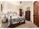Warm bedroom with ornate details, a unique bed frame, and a view into the bathroom at 23465 S 202Nd St, Queen Creek, AZ 85142