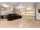 Bright, spacious garage with a sleek SUV parked inside and visible overhead storage racks and equipment at 23465 S 202Nd St, Queen Creek, AZ 85142