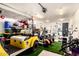 Spacious garage featuring a yellow golf cart, turf accent, exercise equipment, and ample storage space at 23465 S 202Nd St, Queen Creek, AZ 85142