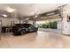 Open garage showcasing a black SUV parked inside, with a view of the landscaped backyard and basketball court at 23465 S 202Nd St, Queen Creek, AZ 85142