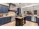 Modern kitchen features a stone oven hood, stainless appliances, and a spacious center island at 23465 S 202Nd St, Queen Creek, AZ 85142