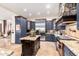 Modern kitchen features a stone oven hood, stainless appliances, and a spacious center island at 23465 S 202Nd St, Queen Creek, AZ 85142