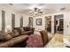 Comfortable living room with leather furniture, ceiling fan and an exercise area in the background at 23465 S 202Nd St, Queen Creek, AZ 85142
