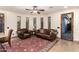 Sitting area with neutral walls, ceiling fan and leather chair and sofa with decorative rug and small windows at 23465 S 202Nd St, Queen Creek, AZ 85142