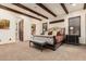Elegant primary bedroom with wood beam ceiling, plantation shutters, and a seating bench at 23465 S 202Nd St, Queen Creek, AZ 85142
