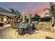 Expansive backyard with an outdoor kitchen, covered patio, dining area, pool, and mature landscaping at 23465 S 202Nd St, Queen Creek, AZ 85142