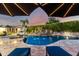 Luxury backyard pool featuring rock waterfall, spa, and sun loungers under shaded umbrellas at 23465 S 202Nd St, Queen Creek, AZ 85142