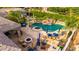 A luxurious backyard featuring a pool with waterfall, spa, outdoor kitchen, and fire pit at 23465 S 202Nd St, Queen Creek, AZ 85142