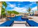 Backyard pool features palm trees, a waterfall feature, and lounge chairs at 23465 S 202Nd St, Queen Creek, AZ 85142