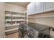 Bright laundry room with front loading washer and dryer, plus ample shelving for storage at 2366 E Spruce Dr, Chandler, AZ 85286