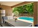 Relaxing covered patio seating area overlooking the inviting swimming pool in a serene backyard setting at 2405 E Lynwood Cir, Mesa, AZ 85213