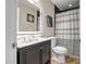 Stylish bathroom featuring black and white striped shower curtain, vanity with sink, and a modern LED mirror at 2405 E Lynwood Cir, Mesa, AZ 85213