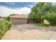 Lovely home boasts a tile roof, two-car garage, and mature desert landscaping at 2405 E Lynwood Cir, Mesa, AZ 85213