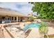 Tranquil backyard retreat featuring a sparkling pool, covered patio, and well-manicured landscaping for outdoor enjoyment at 2405 E Lynwood Cir, Mesa, AZ 85213