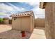 Backyard storage shed with a clean design, tile roof, and convenient access from the walkway at 2405 E Lynwood Cir, Mesa, AZ 85213