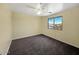 Neutral bedroom features carpet, ceiling fan, and a window overlooking neighborhood homes at 2521 N Franz Ln, Casa Grande, AZ 85122