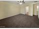 Spacious bedroom with a ceiling fan, plush carpet, and an adjoining bathroom at 2521 N Franz Ln, Casa Grande, AZ 85122