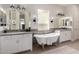 Elegant bathroom featuring dual vanities, modern lighting, and a luxurious claw-foot soaking tub at 2605 S Quaintance St, Gilbert, AZ 85295