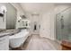 Bright bathroom with freestanding tub, dual vanities, a window, and a glass-enclosed shower, showcasing a clean and modern space at 2605 S Quaintance St, Gilbert, AZ 85295
