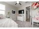 Bright bedroom featuring a TV, white dresser, and a heart-shaped decorative mirror at 2605 S Quaintance St, Gilbert, AZ 85295