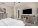 Cozy bedroom features neutral tones, wood furniture, and a modern TV at 2605 S Quaintance St, Gilbert, AZ 85295
