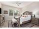 Inviting bedroom with a decorative wood-framed bed, neutral decor, ceiling fan, and a patterned area rug at 2605 S Quaintance St, Gilbert, AZ 85295