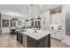 Spacious kitchen features a central island, pendant lighting, stainless steel appliances and connects to the dining and living areas at 2605 S Quaintance St, Gilbert, AZ 85295