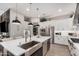 Bright kitchen boasts stainless appliances, white cabinets, large island with sink, and stylish pendant lighting at 2605 S Quaintance St, Gilbert, AZ 85295