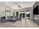 Bright living room features hardwood floors, a large sectional sofa, and sliding glass doors to the backyard at 2605 S Quaintance St, Gilbert, AZ 85295