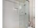 Glass enclosed shower with white tiled walls, rainfall shower head, and a built-in niche at 2605 S Quaintance St, Gilbert, AZ 85295
