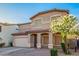 Exterior view of a stucco home with multiple windows and a front yard tree at 2652 E Riviera Dr, Chandler, AZ 85249